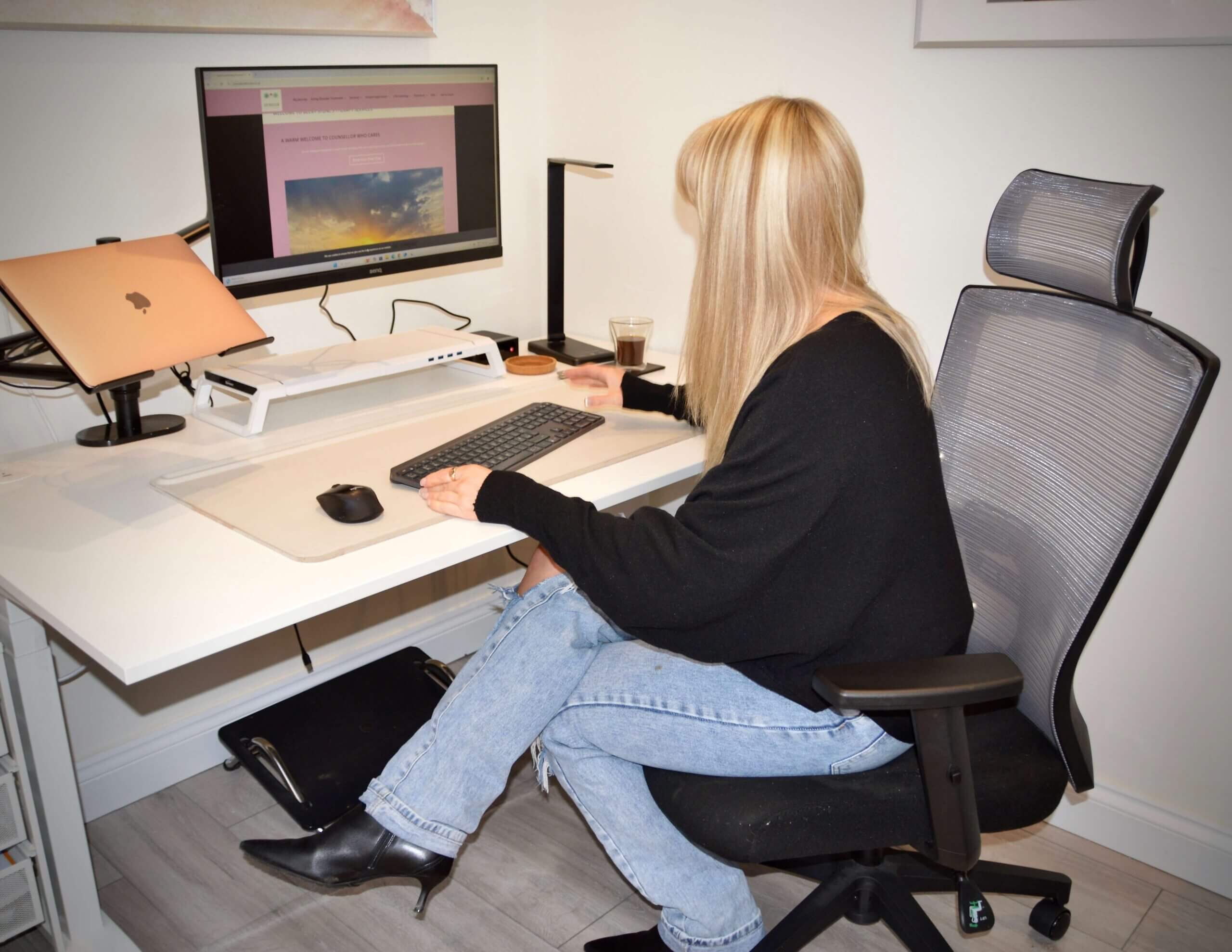 Therapist Becky Stone working behind the scenes on therapy business tasks Becky Stone, therapist and business owner, working at her desk on therapy website, admin, and client support tasks.
