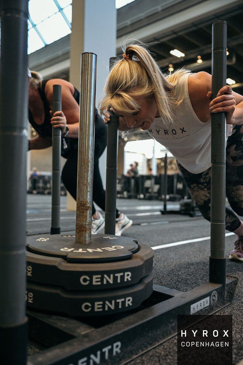 strength-training-bone-density-benefits Woman lifting weights as part of strength training to improve bone density and mental health