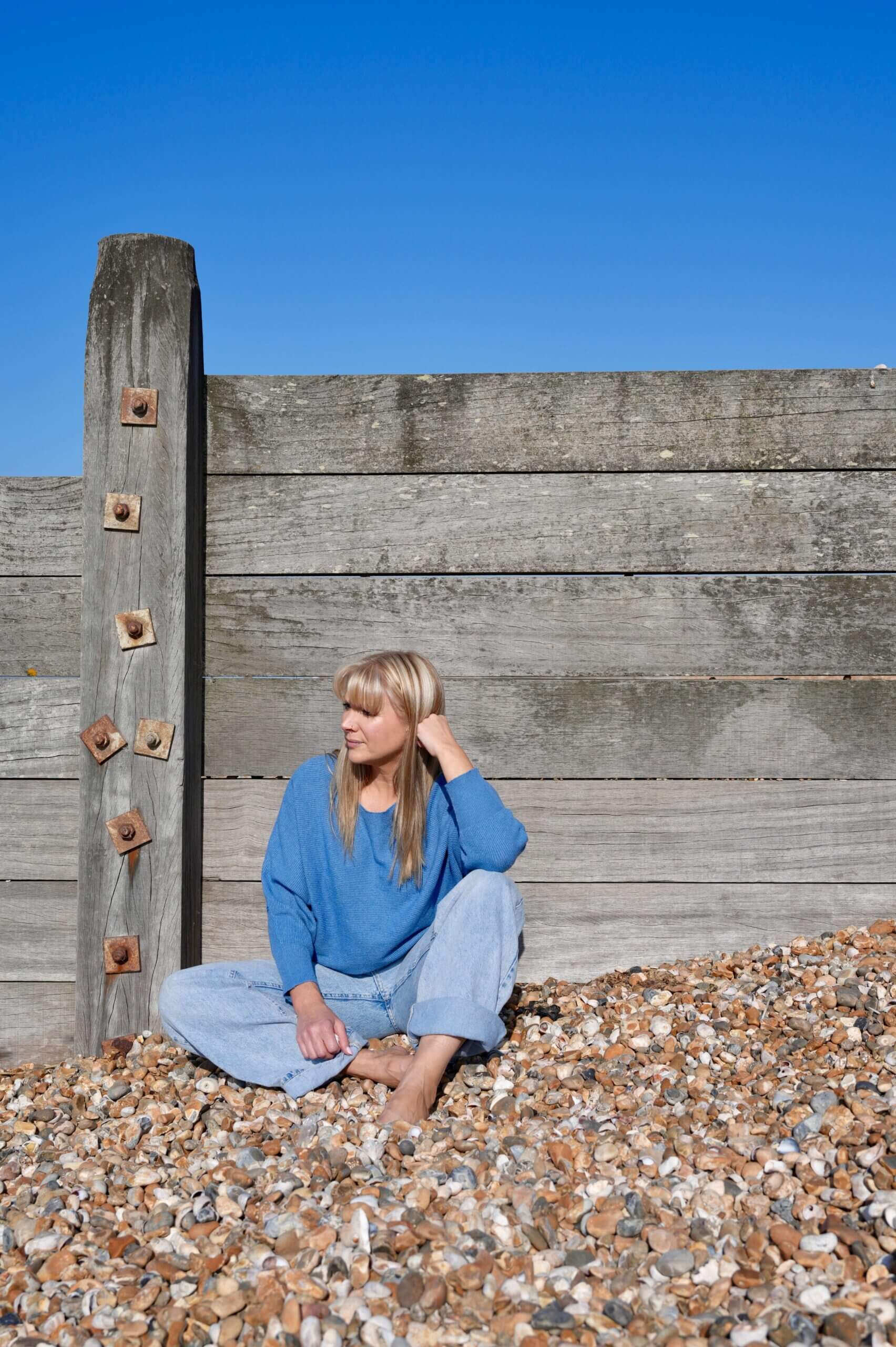 Becky Stone – Neurodivergent Eating Disorder Therapist in Canterbury Becky Stone, eating disorder therapist for ADHD and autism, smiling against wooden background in Canterbury.