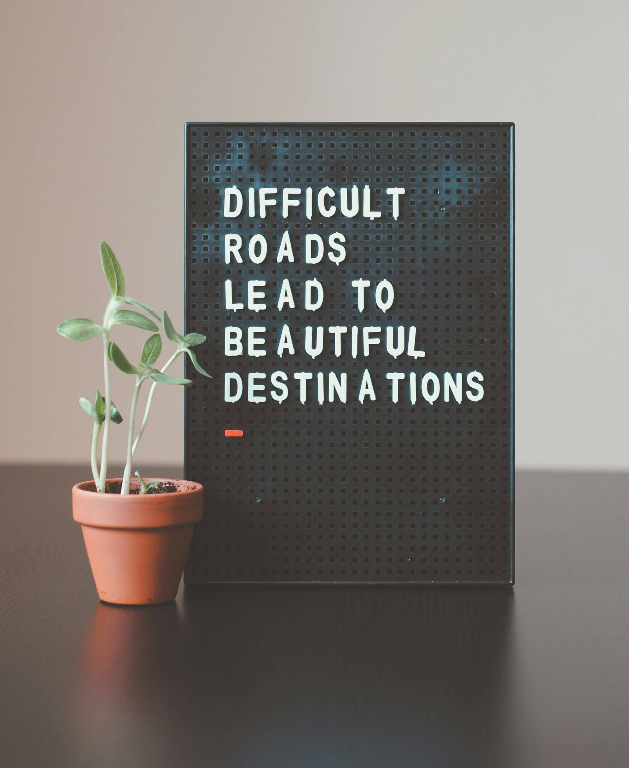 A motivational letterboard that reads “Difficult roads often lead to beautiful destinations”