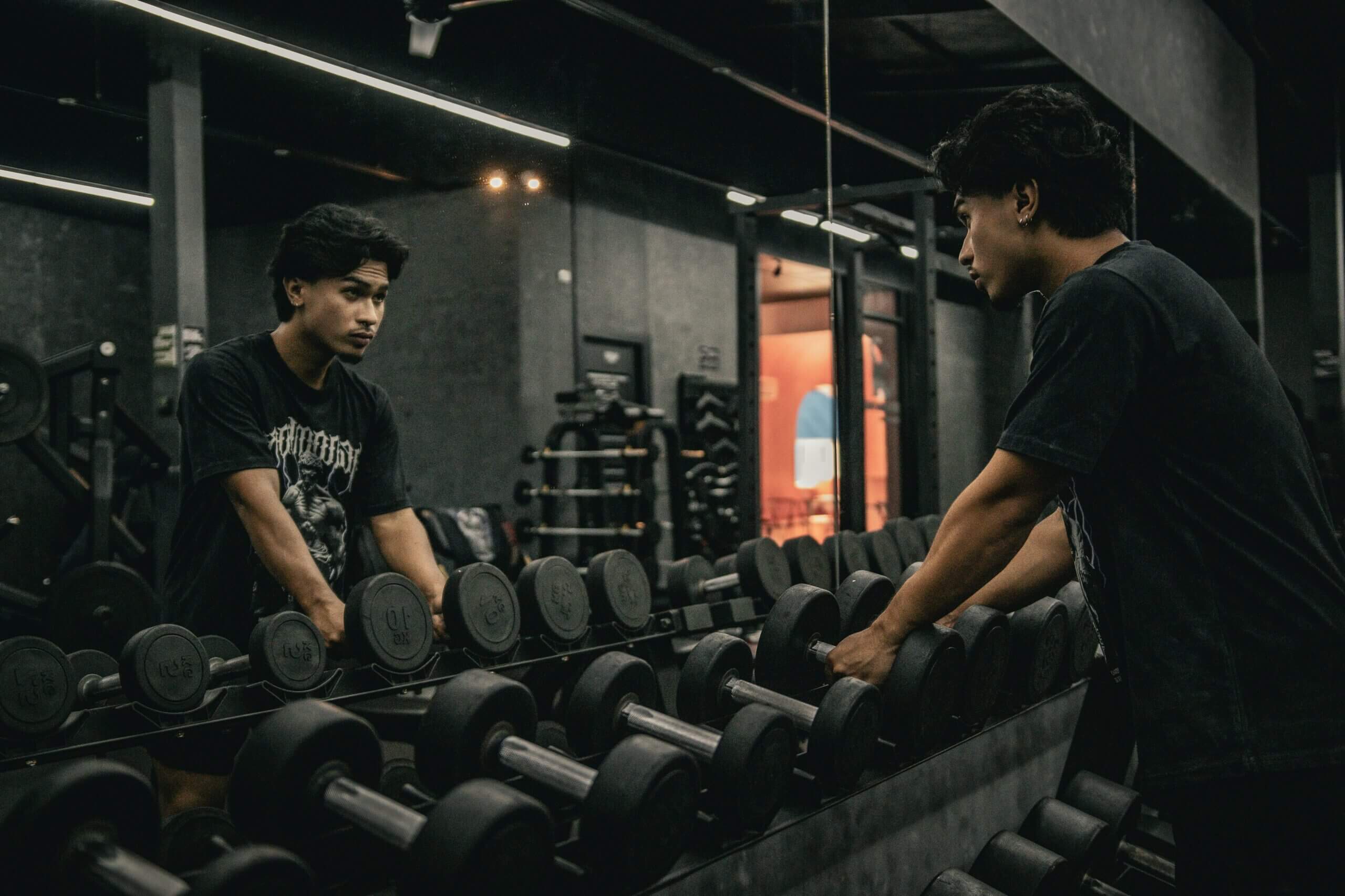Empty gym with weights and equipment, symbolising how boys and men face pressure to build muscle and body image struggles that can lead to eating disorders.
