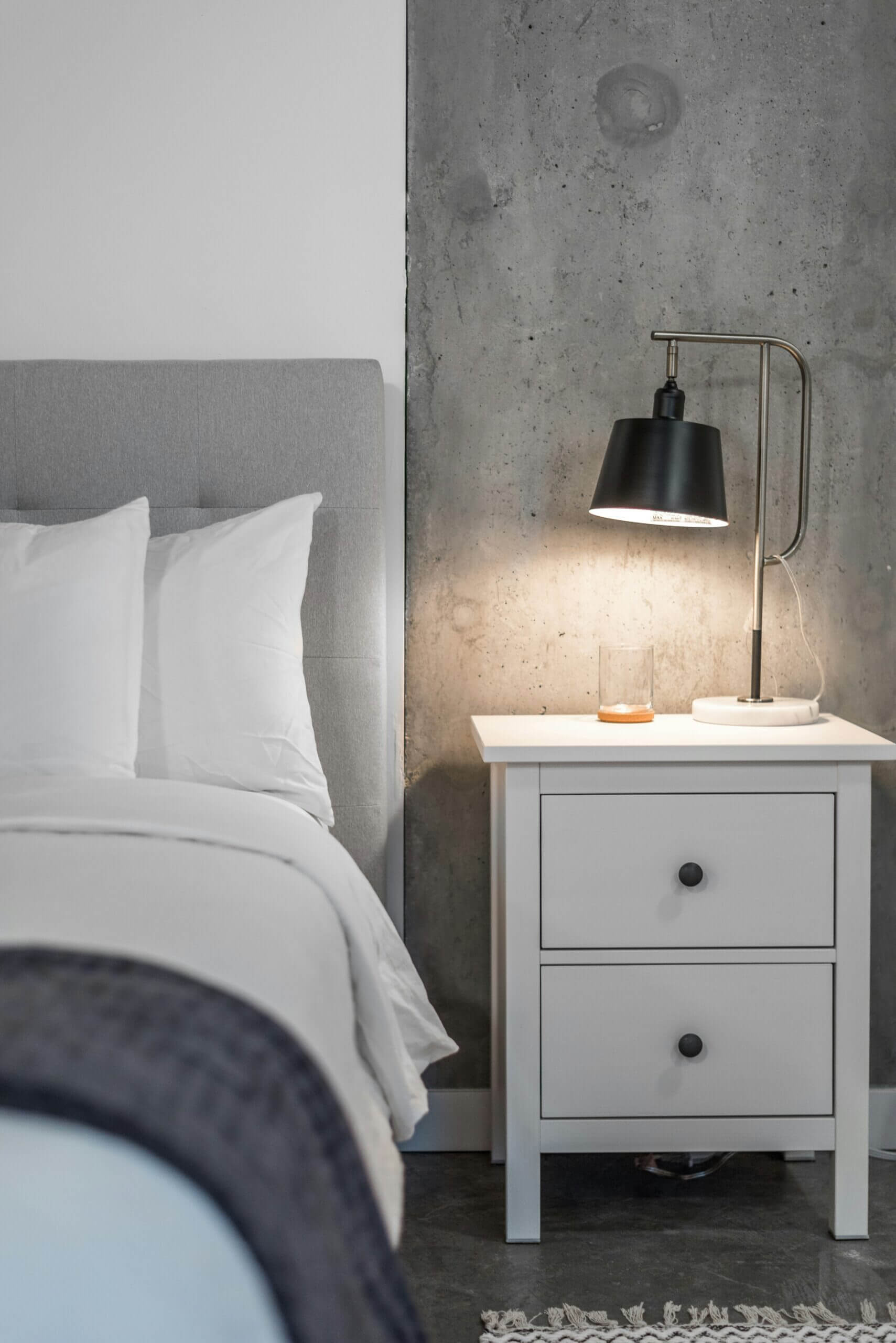 Sleep, Rest and Nervous System Regulation Calm bedroom at night with bedside lamp and bed, representing sleep, rest and nervous system regulation for stress recovery.