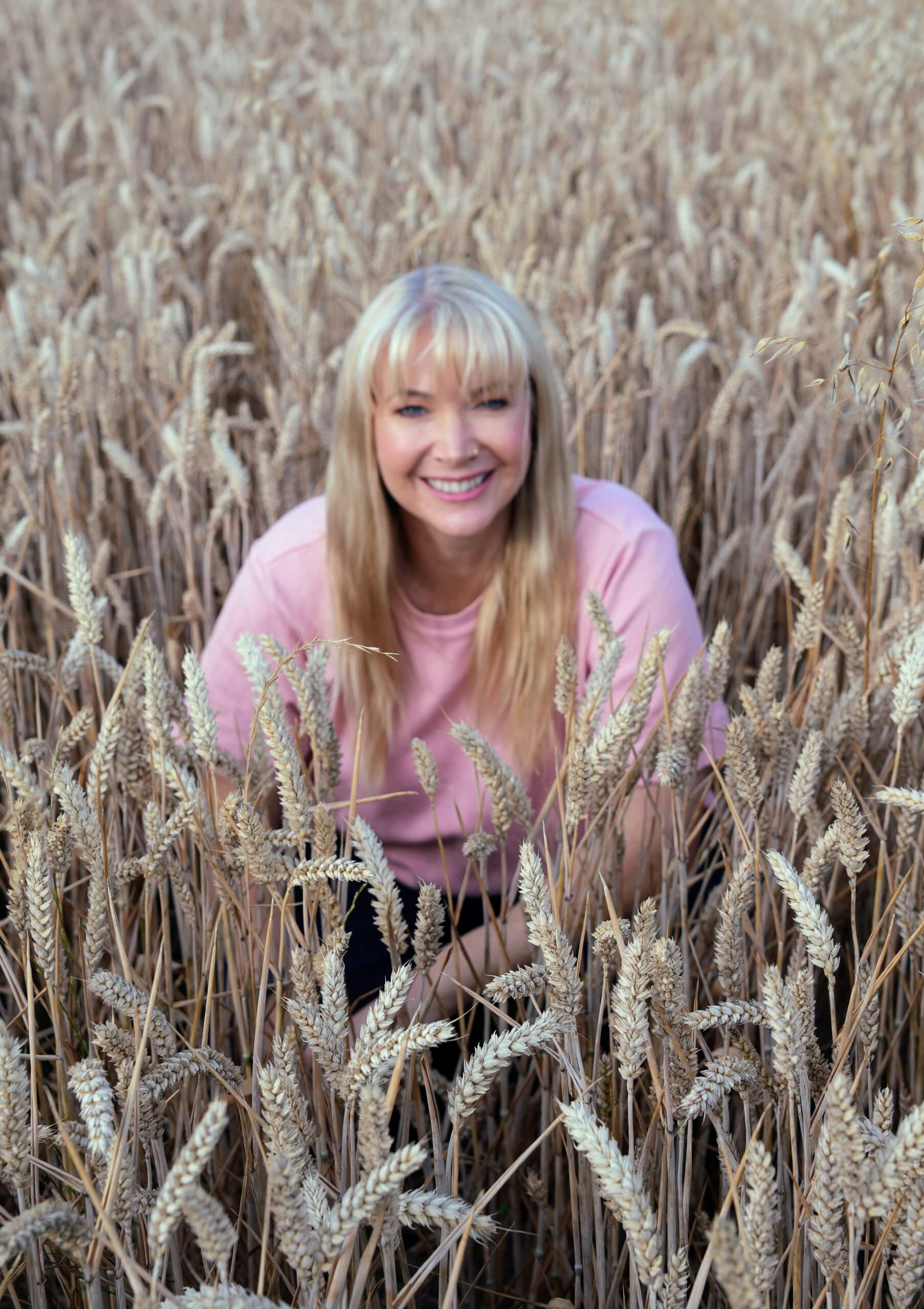 Rebecca Stone | ADHD Coach in Canterbury Rebecca Stone, ADHD coach in Canterbury, smiling in a wheat field.